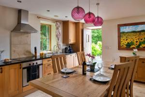 a kitchen with a wooden table with chairs and a dining room at Finest Retreats - Buzzards View in Eglwys-Fâch