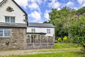 an old stone house with a gate and a yard at Finest Retreats - Buzzards View in Eglwys-Fâch