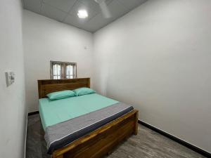 a bedroom with a bed in a white room at Aara Holiday Home in Trincomalee