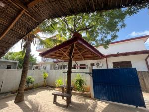 a table and a bench in front of a building at Aara Holiday Home in Trincomalee