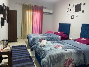 a room with two beds with blue comforters at Zein Pyramids View - Guest House in Cairo