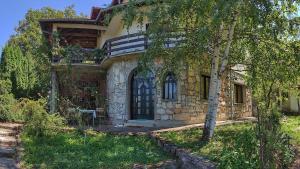 a stone house with a tree in front of it at Apartman Borići in Soko Banja