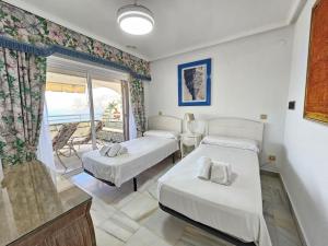 a bedroom with two beds and a balcony at Apartamento Las Terrazas in La Herradura