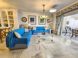 a living room with a blue couch and a table at Apartamento Las Terrazas in La Herradura