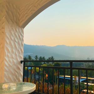 a balcony with a table and a view of the mountains at Chaweng Residence in Chaweng