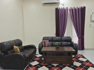 a living room with a leather couch and a coffee table at SERI IBAI DAMAI in Kuala Terengganu
