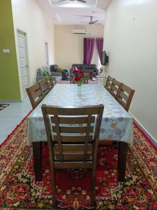 a dining room table with chairs and a vase of flowers on it at SERI IBAI DAMAI in Kuala Terengganu +13 photos