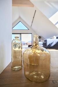 dos botellas de vidrio sentadas sobre una mesa de madera en Designapartment Salzburg en Salzburgo