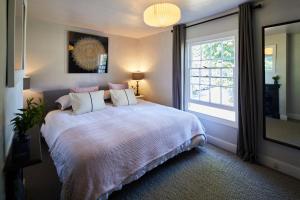 a bedroom with a large bed and a window at Cottage on The Croft in Hungerford