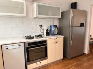 uma cozinha com um fogão e um frigorífico em בית בקיבוץ em Hagoshrim