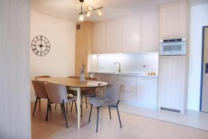 a kitchen and dining room with a table and chairs at Apartamenty In - Jastrzębia Góra - Pilice in Jastrzębia Góra +14 photos