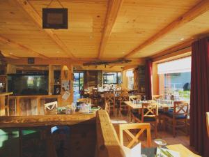Un restaurante con techos de madera y mesas y sillas. en Apartment in France near the Alps, en La Toussuire