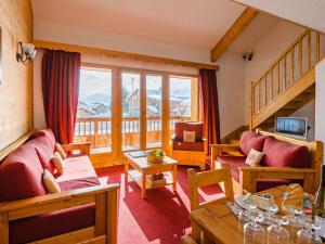 Una sala de estar con sofás y una gran ventana. en Apartment in France near the Alps, en La Toussuire