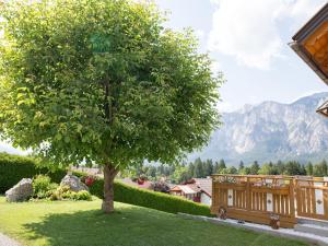 a tree in the middle of a yard with a bench at Cosy apartment in Arnoldstein with parking lot in Arnoldstein