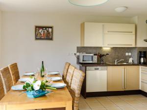 uma cozinha com uma mesa de madeira com flores em Beautiful vacation home near a Breton oyster fishing village em Cancale
