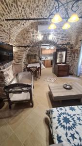 a living room with tables and a stone wall at Olympus in Olýmpoi