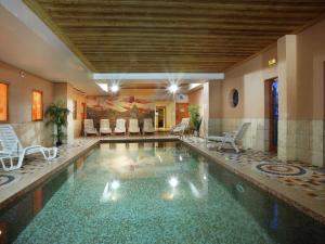 a swimming pool in a building with chairs in it at Apartment on the slopes in the big ski area Grandes Rousses in Oz