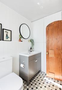 a bathroom with a sink and a toilet and a mirror at Cottage on The Croft in Hungerford