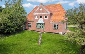 een groot rood bakstenen huis met een groene tuin bij Kromose in Tagholm