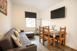 a living room with a couch and a table and chairs at Spacious 2 BR Apartments - 5 mins from QMC, Universities and City Centre! in Nottingham