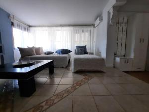 ein Wohnzimmer mit einem Sofa und einem Tisch in der Unterkunft Casa Olena in Nea Potidaea