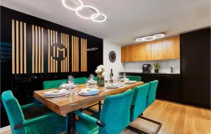 a dining room with a wooden table and green chairs at Lovely Home In Donja Stubica With Outdoor Swimming Pool in Donja Stubica