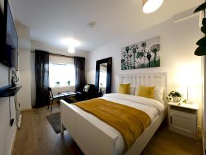 1 dormitorio con 1 cama blanca grande con almohadas amarillas en Pass the Keys Cosy Studio Flat Close To Bexleyheath Centre, en Bexleyheath