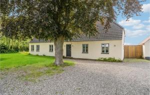 Una casa blanca con un árbol delante. en 5 Bedroom Cozy Home In Odense N, en Odense