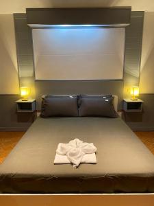 Una cama con una bata blanca con dos luces en Sunset Seaview Patong en Patong Beach