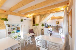 a kitchen and dining room with white tables and chairs at Corte Lusenzo in Chioggia