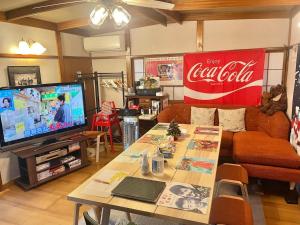 鐮倉的住宿－Umimachi Seikatsu Koshigoe Minatokan - Vacation STAY 55291v，客厅配有古柯标志和桌子