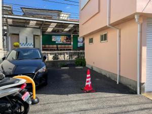 um carro estacionado num parque de estacionamento ao lado de um edifício em Umimachi Seikatsu Koshigoe Minatokan - Vacation STAY 55291v em Kamakura