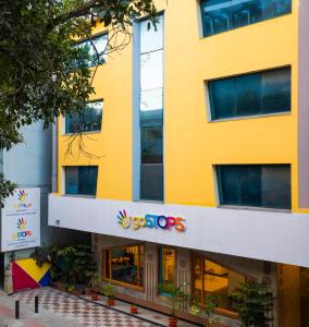 a yellow building with a syseyes sign on it at goSTOPS Bengaluru, Gandhi Nagar Majestic in Bangalore