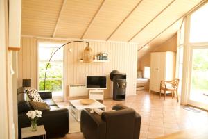 a living room with two couches and a television at Timmenhus - Ferienhäuser am Feldrand in Timmendorfer Strand