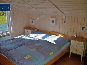 a bedroom with a bed in a room with a window at Timmenhus - Ferienhäuser am Feldrand in Timmendorfer Strand