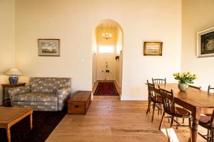 a living room with a table and a couch at Charming Historical Cottage in Graaff-Reinet