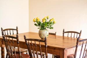 a vase of flowers sitting on top of a wooden table at Charming Historical Cottage in Graaff-Reinet +22 photos