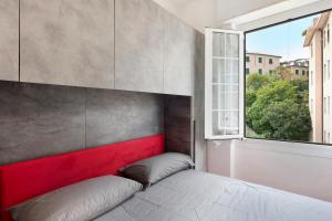 Schlafzimmer mit einem Bett mit einem roten Kopfteil und einem Fenster in der Unterkunft Apartment Aquarium Principe in Genua