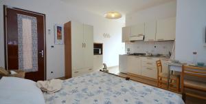 a kitchen with a bed and a table in a room at Appartamenti Gaby in Lignano Sabbiadoro
