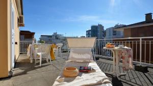 balcón con silla y mesa en Appartamenti Gaby, en Lignano Sabbiadoro