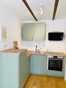 a kitchen with blue cabinets and a sink at Restaurierter Altbau mit privatem Innenhof & Parkplatz in Großfischlingen