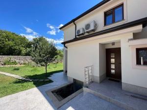 une maison blanche avec une porte et une cour dans l'établissement Apartman David, à Rijeka