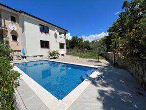 a swimming pool in front of a house at Apartman David in Rijeka