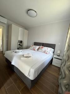 - une chambre avec un grand lit et des draps blancs dans l'établissement Apartman David, à Rijeka