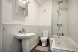 a white bathroom with a sink and a toilet at Spacious 2 BR Apartments - 5 mins from QMC, Universities and City Centre! in Nottingham