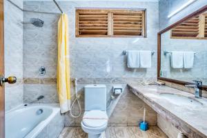 La salle de bains est pourvue d'une baignoire, de toilettes et d'un lavabo. dans l'établissement Fihalhohi Maldives, à Atoll Malé Sud