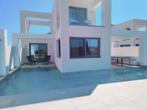 uma casa com uma piscina em frente em Alpha Villas em Gennadi