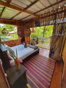 een slaapkamer met een bed en een hangmat in een kamer bij TORTUGA BAY Eco Hotel in El Valle