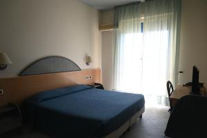 a bedroom with a blue bed and a window at Hotel Baia Turchese in Lampedusa