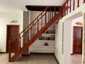 a staircase in a home with a wooden stair case at Le Chevalier Bay Guesthouse in Anse Lazio